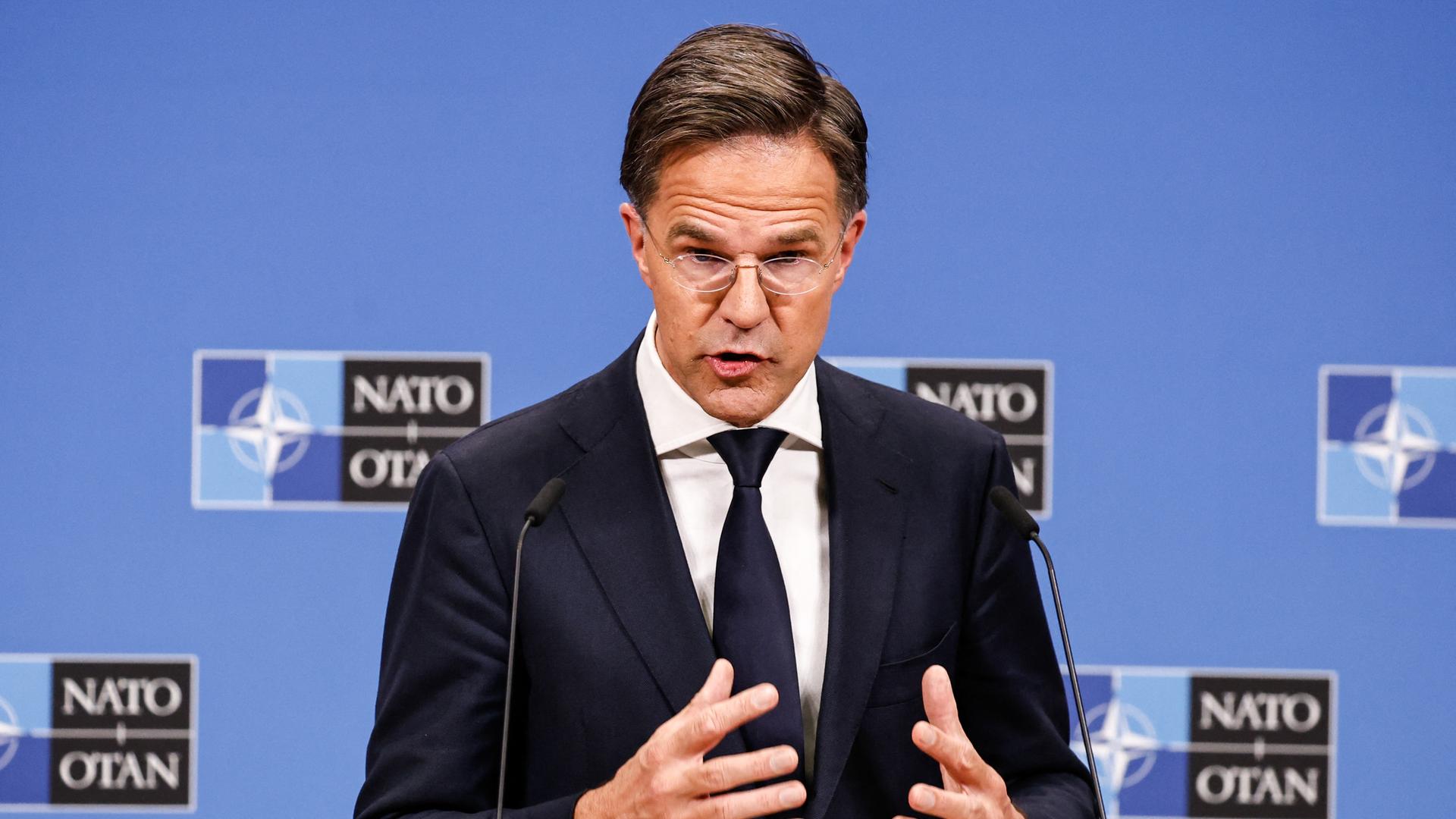 NATO-Generalsekretär Rutte gibt in Brüssel eine Pressekonferenz. Er steht vor zwei Mikrofonen und gestikuliert.