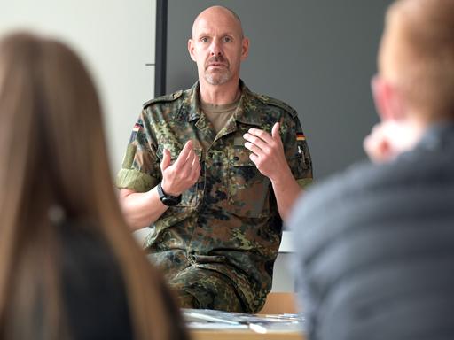 Bundeswehr-Offizier spricht vor einer Gymnasialklasse.