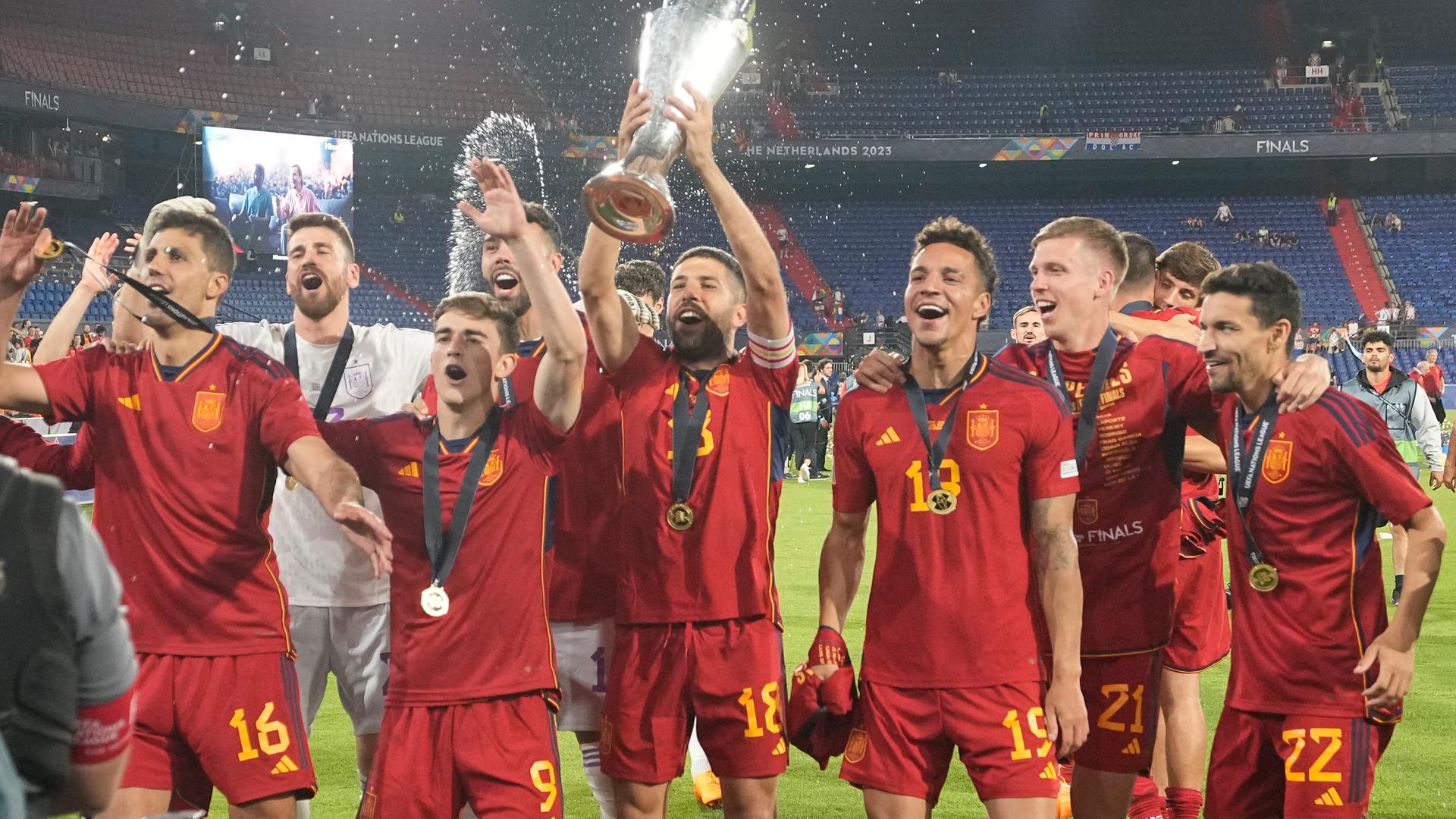 Spanische Spieler feiern mit der Trophäe nach dem Sieg im Endspiel.