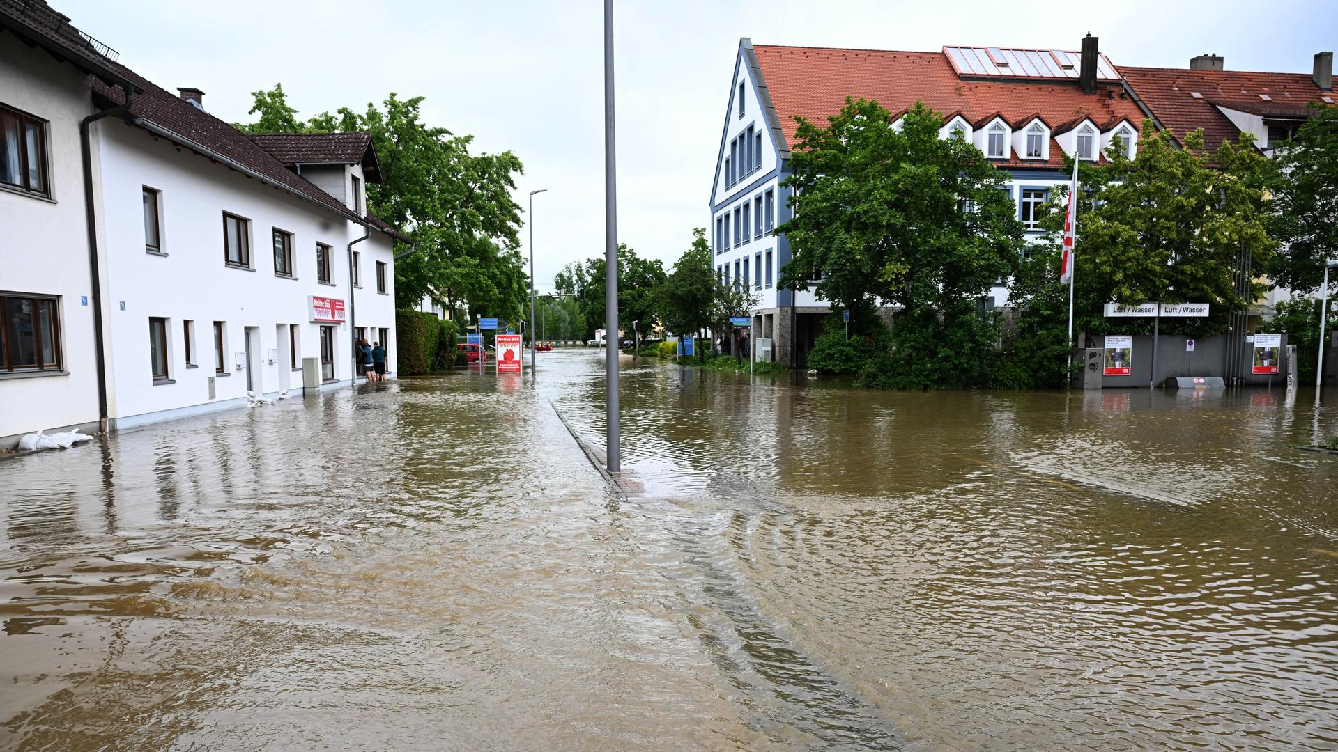 Wasser steht in den Straßen in Allershausen. Nach starken Regenfällen gibt es in der Region Hochwasser mit Überschwemmungen.