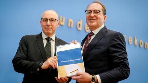 Alexander Dobrindt und Sinan Selenhalten halten gemeinsam den Verfassungsschutzbericht 2024 in die Kamera.
