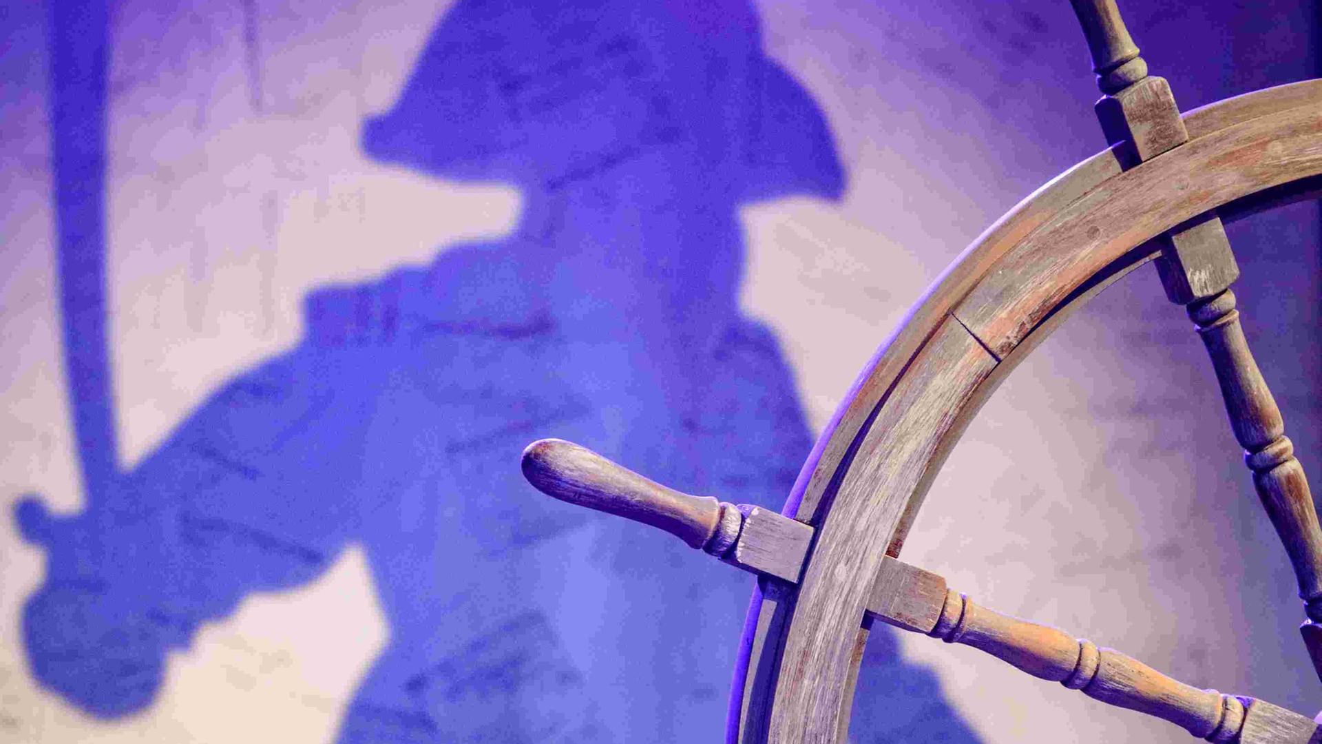 Ein Steuerrad und der Schatten eines Piraten - bei einer Probe für das Stück "Johnny Hübner greift ein" des jungen Theaters Nordhausen am 20. Oktober 2022 in Nordhausen (Thüringen).