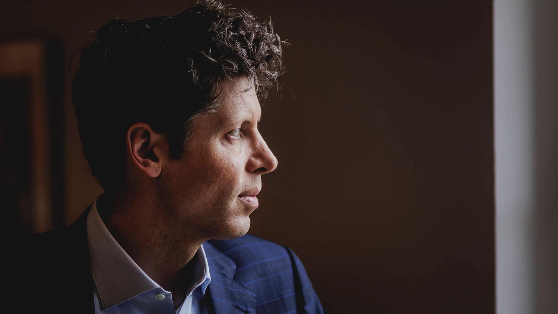 Eine Profilaufnahme von Sam Altman, sein Kopf ist vor einem dunklen Hintergrund aufgenommen.