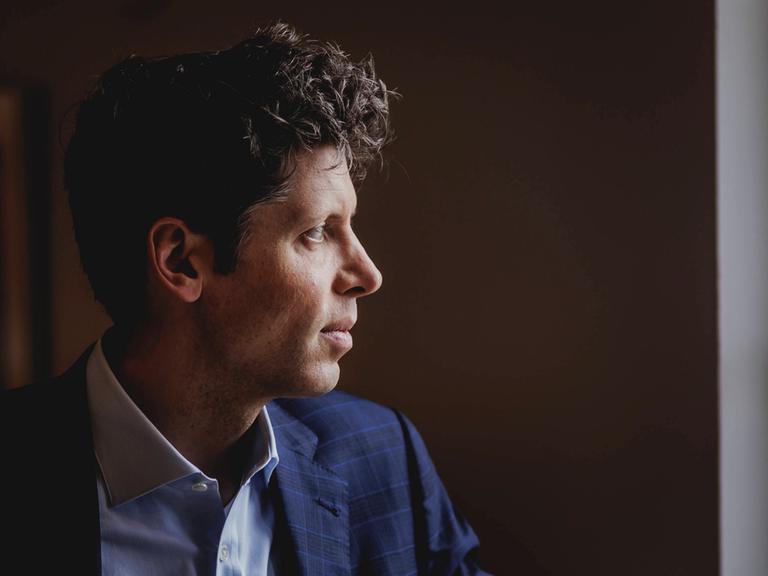 Eine Profilaufnahme von Sam Altman, sein Kopf ist vor einem dunklen Hintergrund aufgenommen.