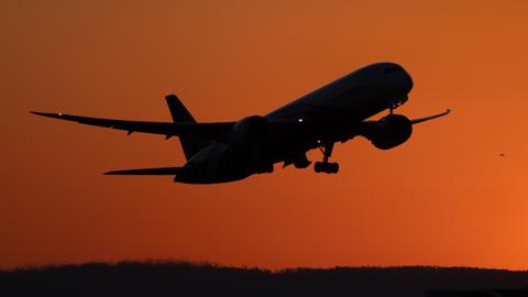 Ein Flugzeug startet im letzten Abendlicht auf dem Flughafen Frankfurt am Main.