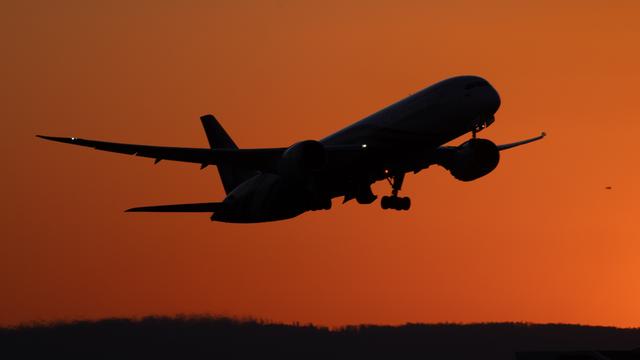 Ein Flugzeug startet im letzten Abendlicht auf dem Flughafen Frankfurt am Main.