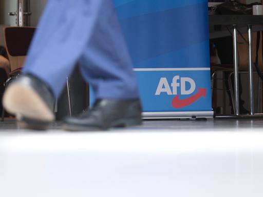 Ein paar schwarze Schuhe vor einem AfD-Logo