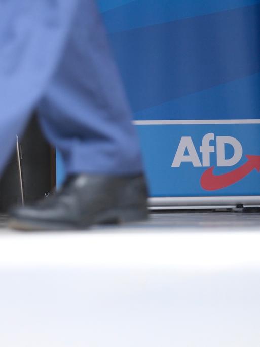 Ein paar schwarze Schuhe vor einem AfD-Logo