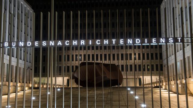 "Bundesnachrichtendienst" steht auf dem Zaun vor einem Gebäudekomplex. Hinter dem Zaun, im Hof, liegt ein Fels. "Bundesnachrichtendienst" steht auf dem Zaun vor einem Gebäudekomplex. Hinter dem Zaun, im Hof, liegt ein Fels.