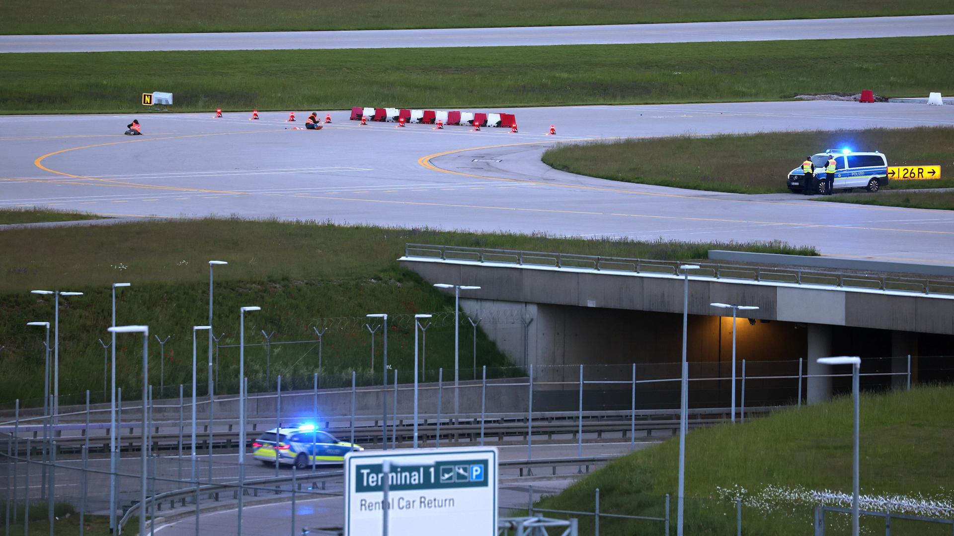 Das Foto zeigt zwei Polizeiautos auf dem Rollfeld des Flughafens München.