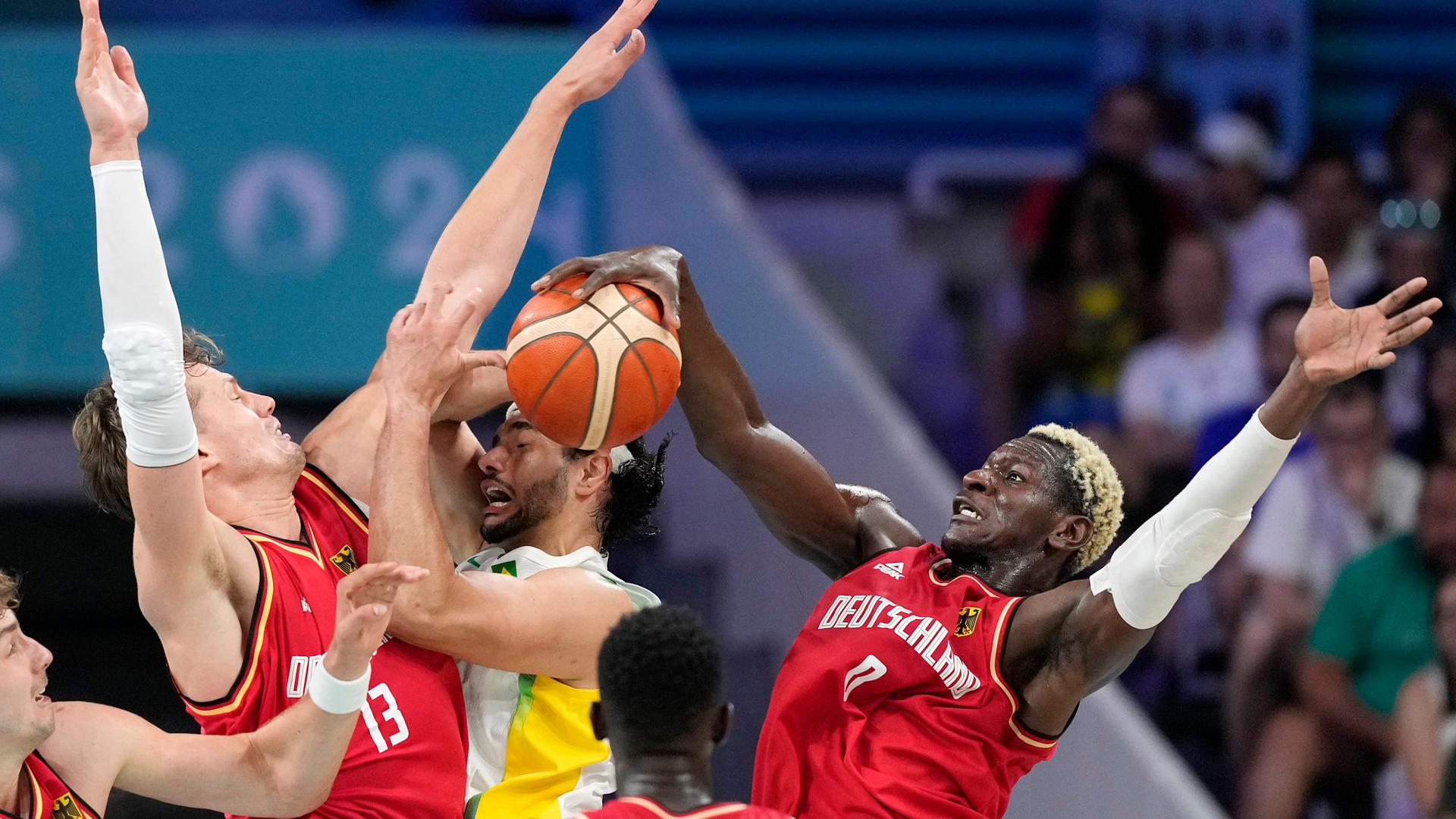 Das Foto zeigt Spieler der brasilianischen sowie der deutschen Olympia-Besketballmannschaft.