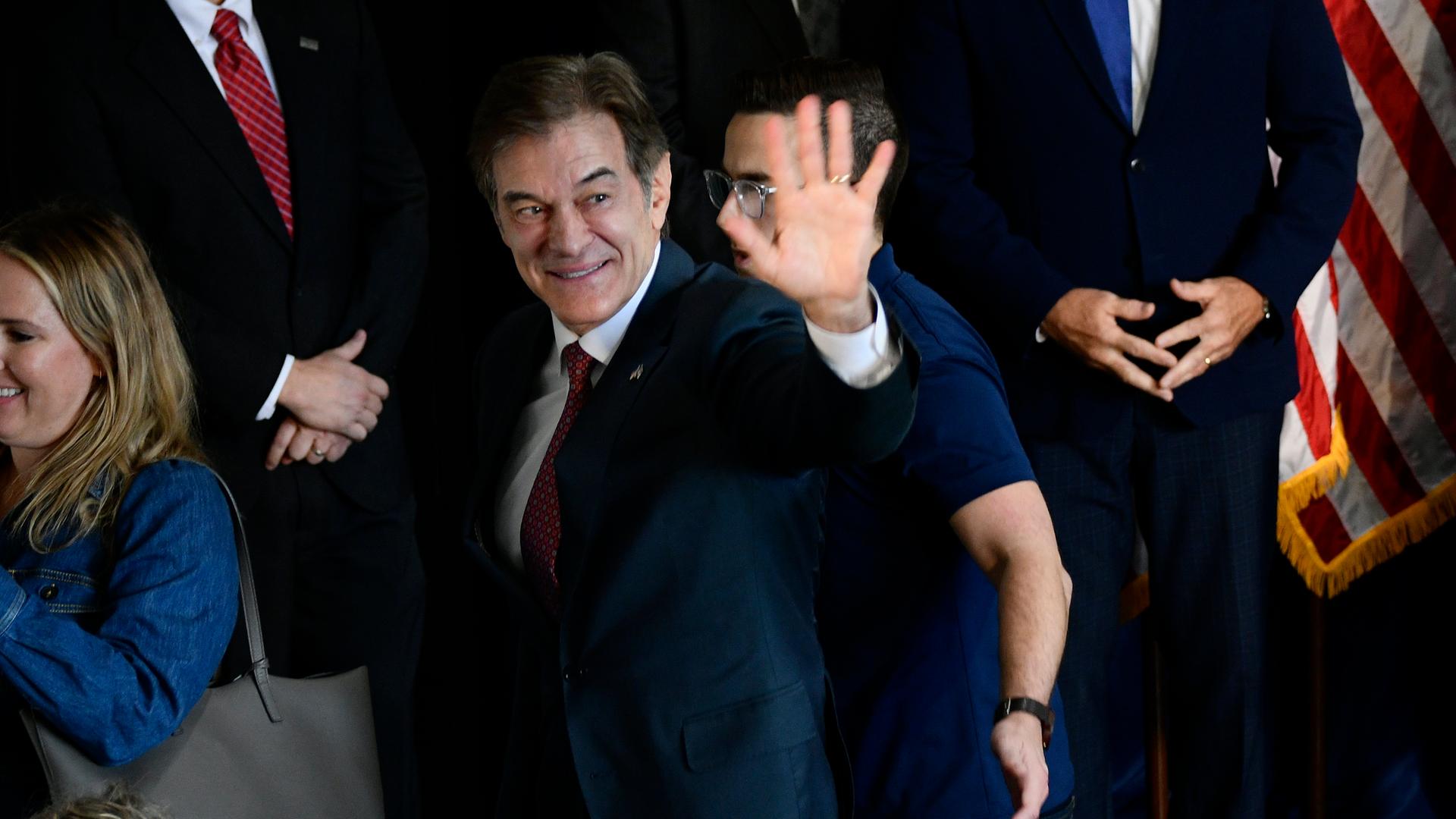 Das Bild zeigt Mehmet Oz, wie er einer Menge auf einer Veranstaltung zuwinkt.