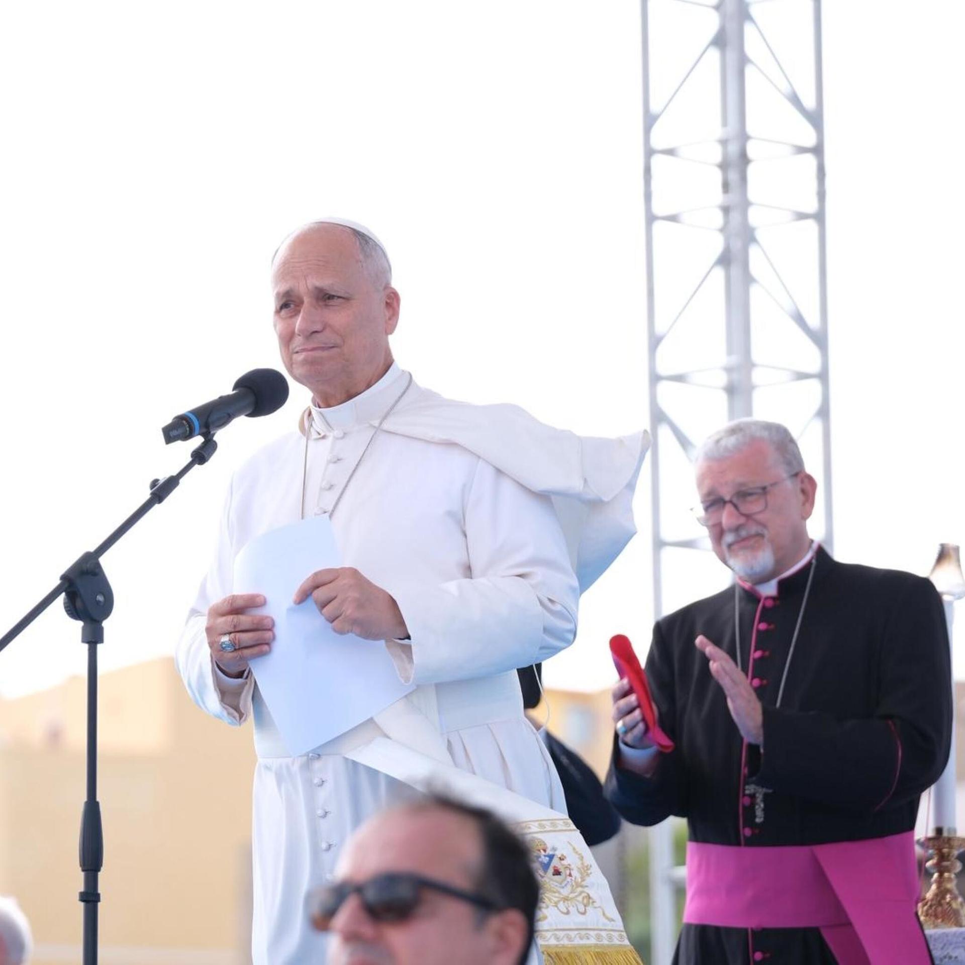 Papst Leo spricht unter freiem Himmel in ein Mikrofon.
