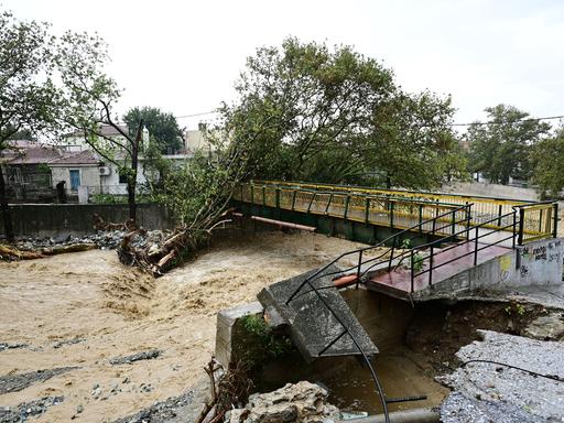 Blick auf die überschwemmte griechische Stadt Volos, Wassermassen haben einen Baum entwurzelt und Brücken zerstört 