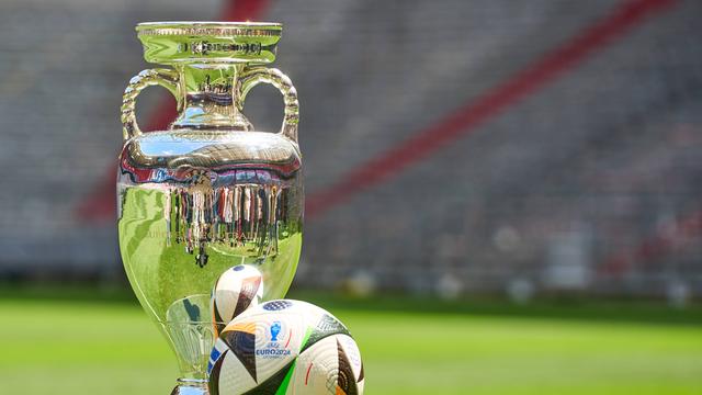 Henri-Delaunay-Pokal der UEFA EURO 2024 zusammen mit dem offiziellen Spielball der Europameisterschaft von Adidas auf dem Spielfeld der Allianz Arena in München