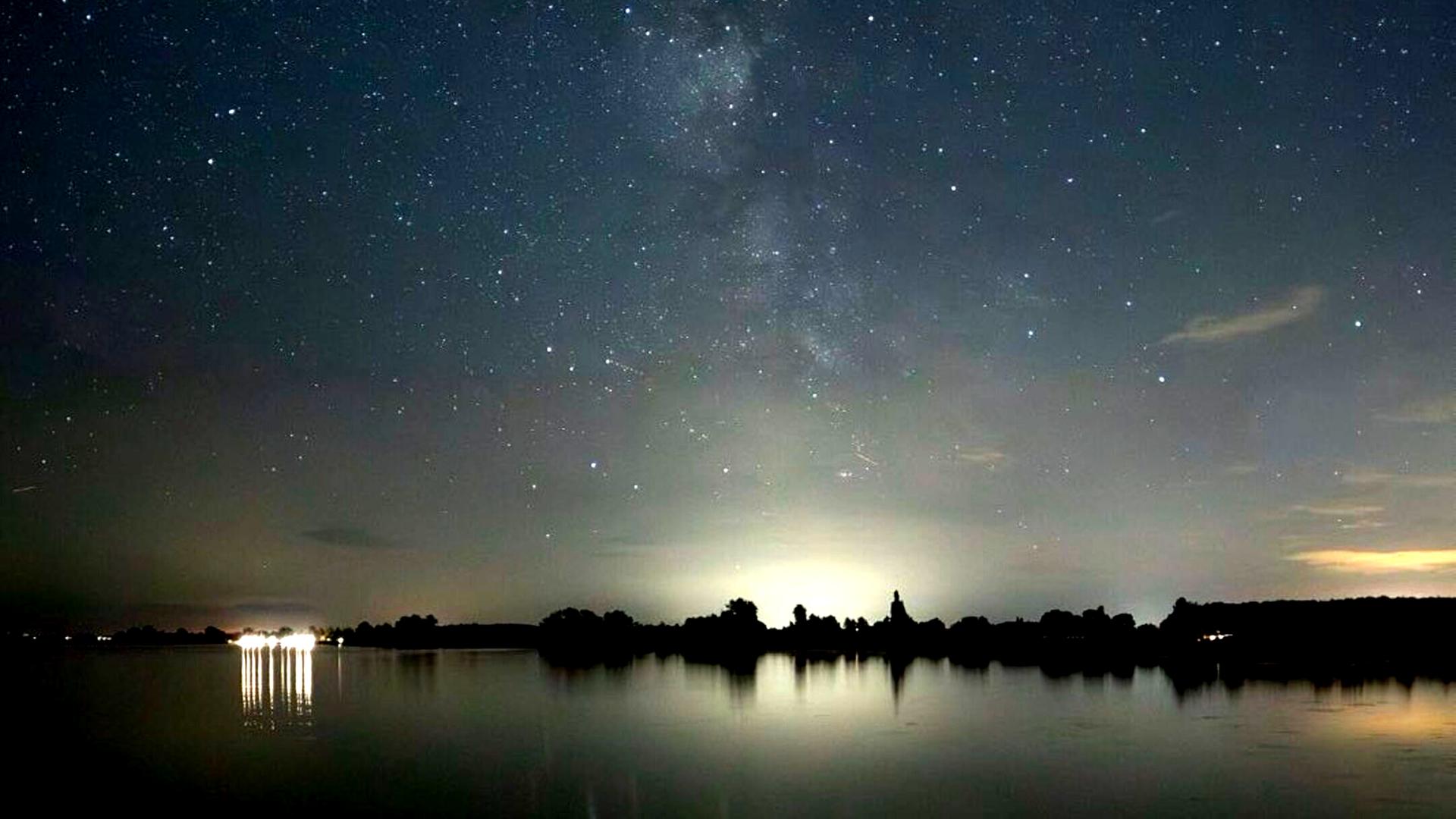 Foto einer nächtlichen Seenlandschaft mit Sternenhimmel