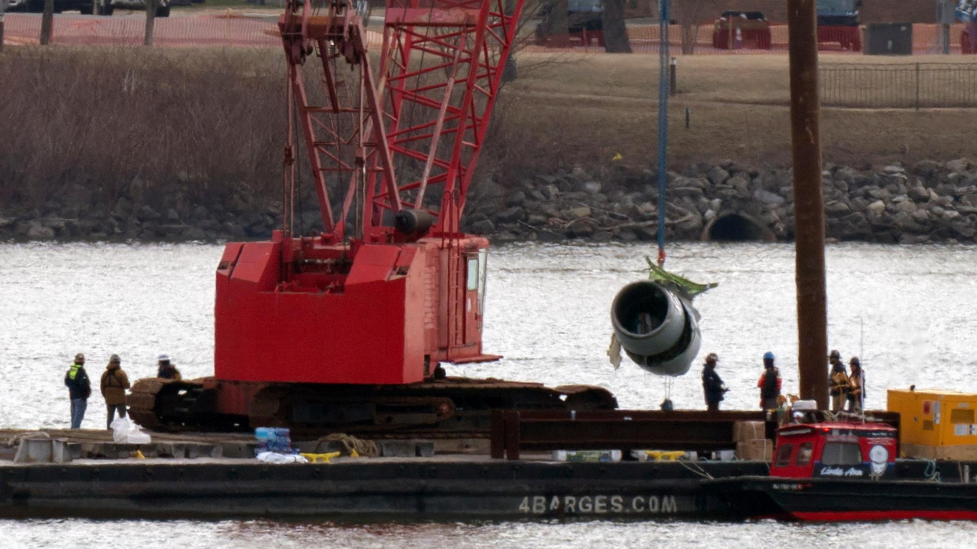 Rettungs- und Bergungsmannschaften ziehen ein Flugzeugtriebwerk hoch, während Kräne in der Nähe des Wracks eines American Airlines-Jets im Potomac River vom Ronald Reagan National Airport arbeiten.