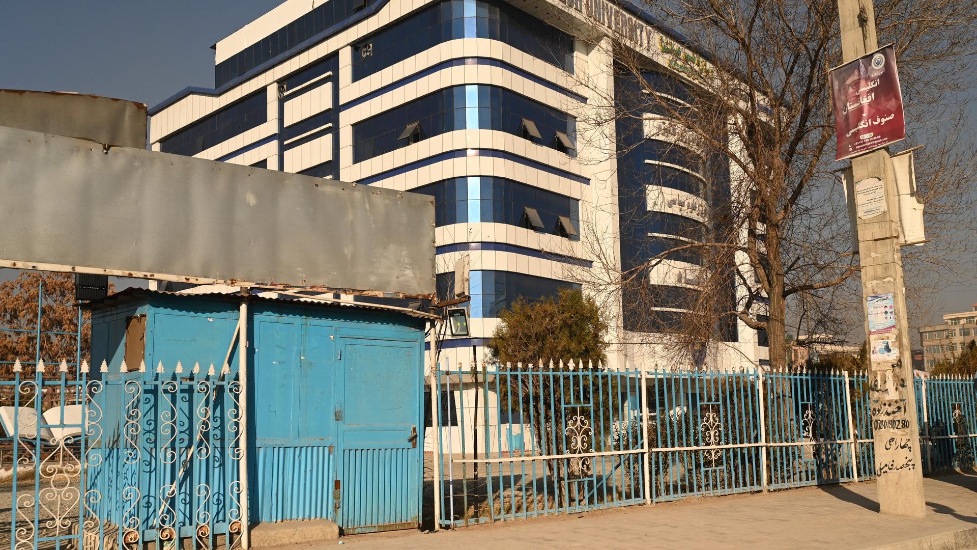 Der geschlossenen Eingang einer Privat-Universität in Kabul in Afghanistan, ein Gebäude mit vier Stockwerken, davor ein Zaun. Der geschlossenen Eingang einer Privat-Universität in Kabul in Afghanistan, ein Gebäude mit vier Stockwerken, davor ein Zaun.