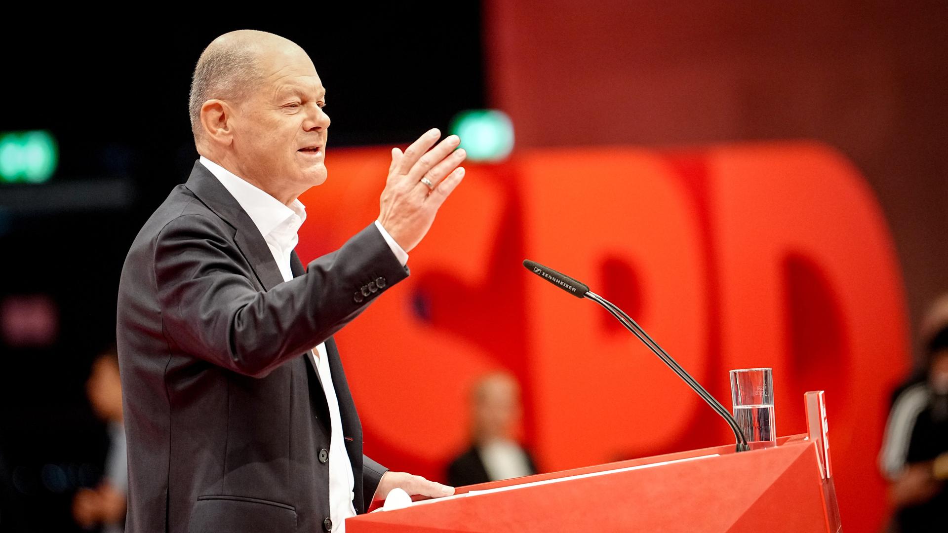 Scholz steht am Rednerpult und gestikuliert. Im Hintergrund ist das Logo der SPD zu sehen. Scholz steht am Rednerpult und gestikuliert. Im Hintergrund ist das Logo der SPD zu sehen.