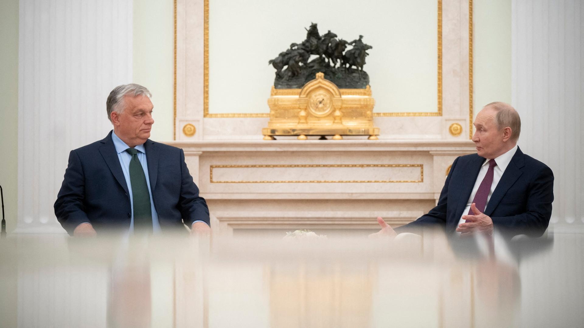 Der ungarische Ministerpräsident und der russische Präsident Putin sitzen sich im Kreml gegenüber und unterhalten sich.