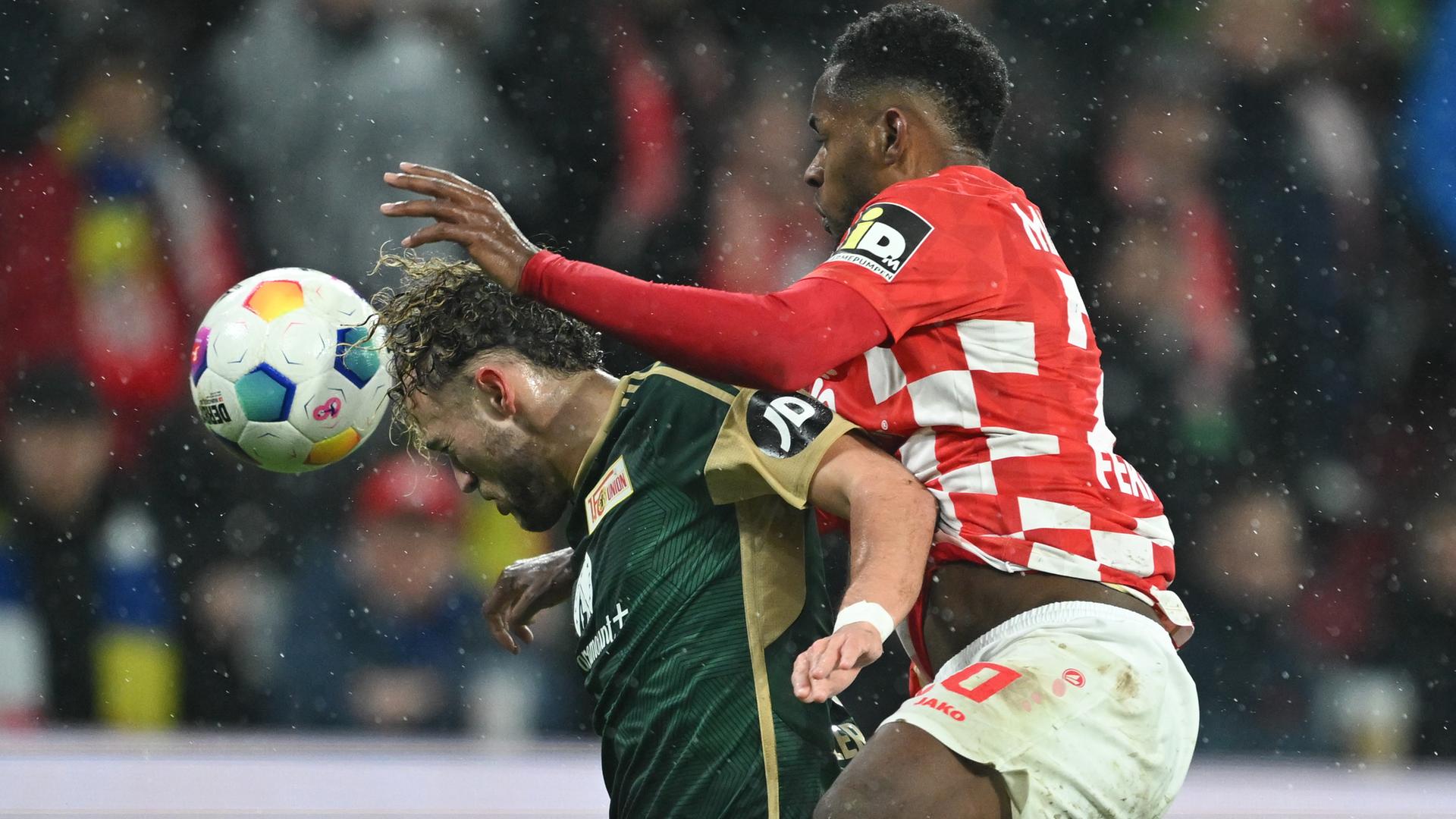 Das Bild zeigt einen Zweikampf um den Ball zwischen dem Mainzer Profi-Fußballer Edimilson Fernandes (r) und Benedict Hollerbach von Union.
