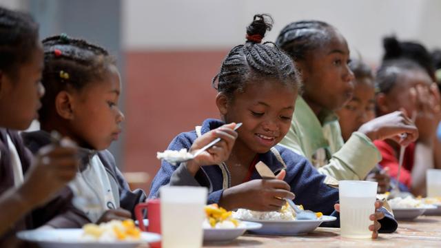 Kinder in einer Schule essen gemeinsam.