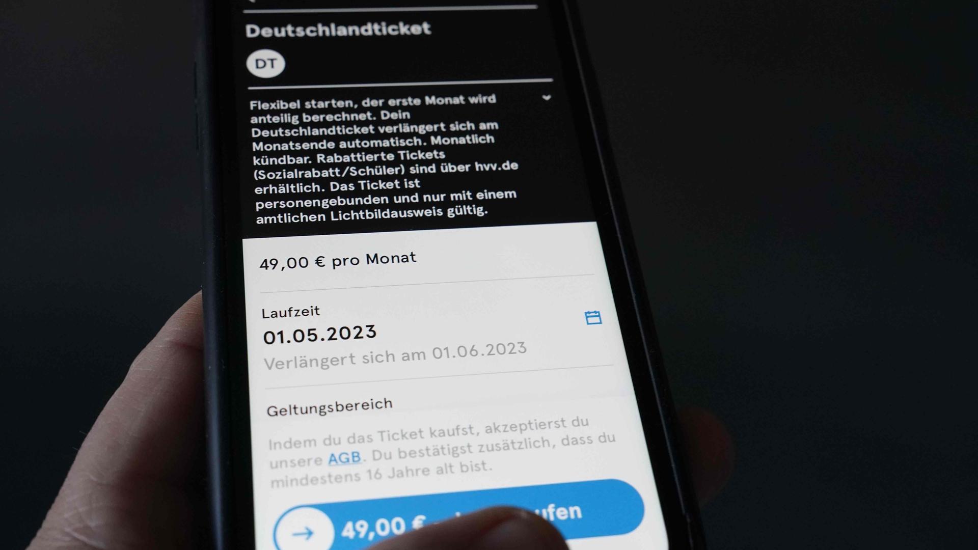 Ein Mann tippt auf seinem Smartphone auf die HVV-Switch-App. 