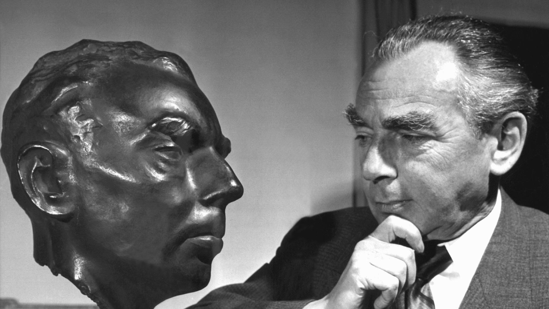 Erich Kästner betrachtet sein Ebenbild aus Bronze im Jahr 1958.