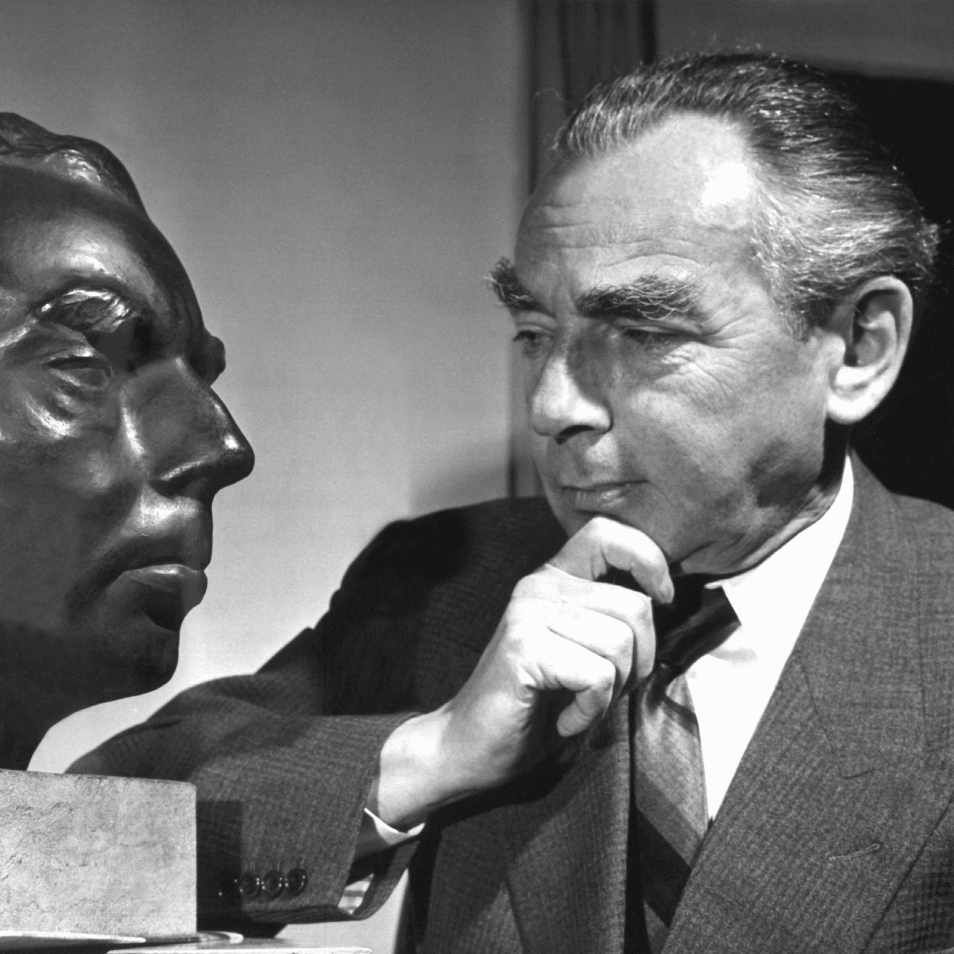Der deutsche Schriftsteller Erich Kästner betrachtet nachdenklich sein Ebenbild, eine vom Bildhauer Frayber geschaffene Bronze-Büste, die 1959 in der bayerischen Staatsgalerie ausgestellt werden soll.