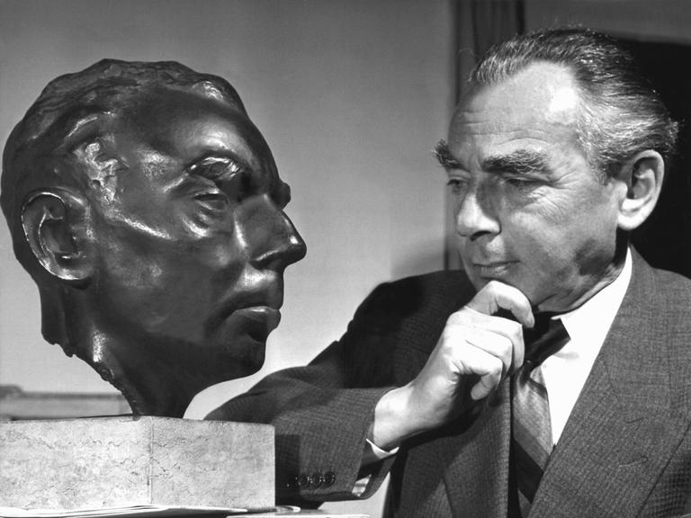 Erich Kästner betrachtet sein Ebenbild aus Bronze im Jahr 1958.