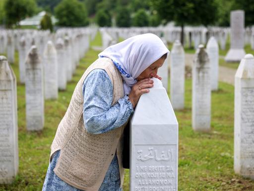 Eine bosnische Muslimim küsst das GRab ihres Sohnes in Srebrenica. 