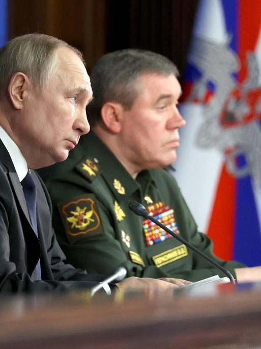 Russlands Präsident Wladimir Putin und Generalstabschef Waleri Gerassimow sitzen nebeneinander 
