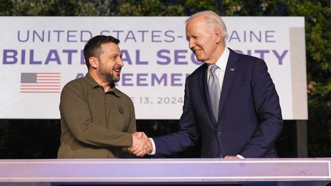 US-Präsident Biden und der ukrainische Präsident Selenskyj reichen sich nach der Unterzeichnung eines Sicherheitsabkommens die Hand. 
