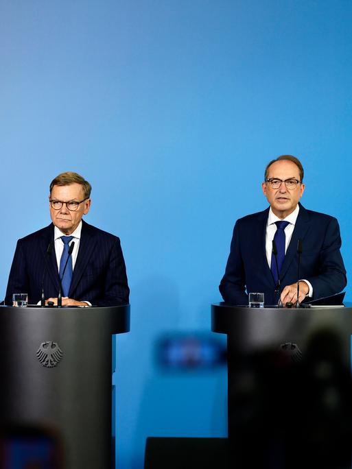 Bundesaussenminister Johann Wadephul (l., CDU) und Bundesminister Alexander Dobrindt (CSU) stehen hinter zwei Rednerpulten vor einem blauen Hintergrund, links ist der Schatten einer Kamera zu erkennen Bundesaussenminister Johann Wadephul (l., CDU) und Bundesminister Alexander Dobrindt (CSU) stehen hinter zwei Rednerpulten vor einem blauen Hintergrund, links ist der Schatten einer Kamera zu erkennen