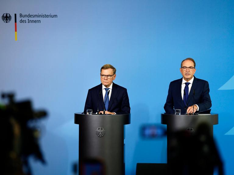 Bundesaussenminister Johann Wadephul (l., CDU) und Bundesminister Alexander Dobrindt (CSU) stehen hinter zwei Rednerpulten vor einem blauen Hintergrund, links ist der Schatten einer Kamera zu erkennen Bundesaussenminister Johann Wadephul (l., CDU) und Bundesminister Alexander Dobrindt (CSU) stehen hinter zwei Rednerpulten vor einem blauen Hintergrund, links ist der Schatten einer Kamera zu erkennen