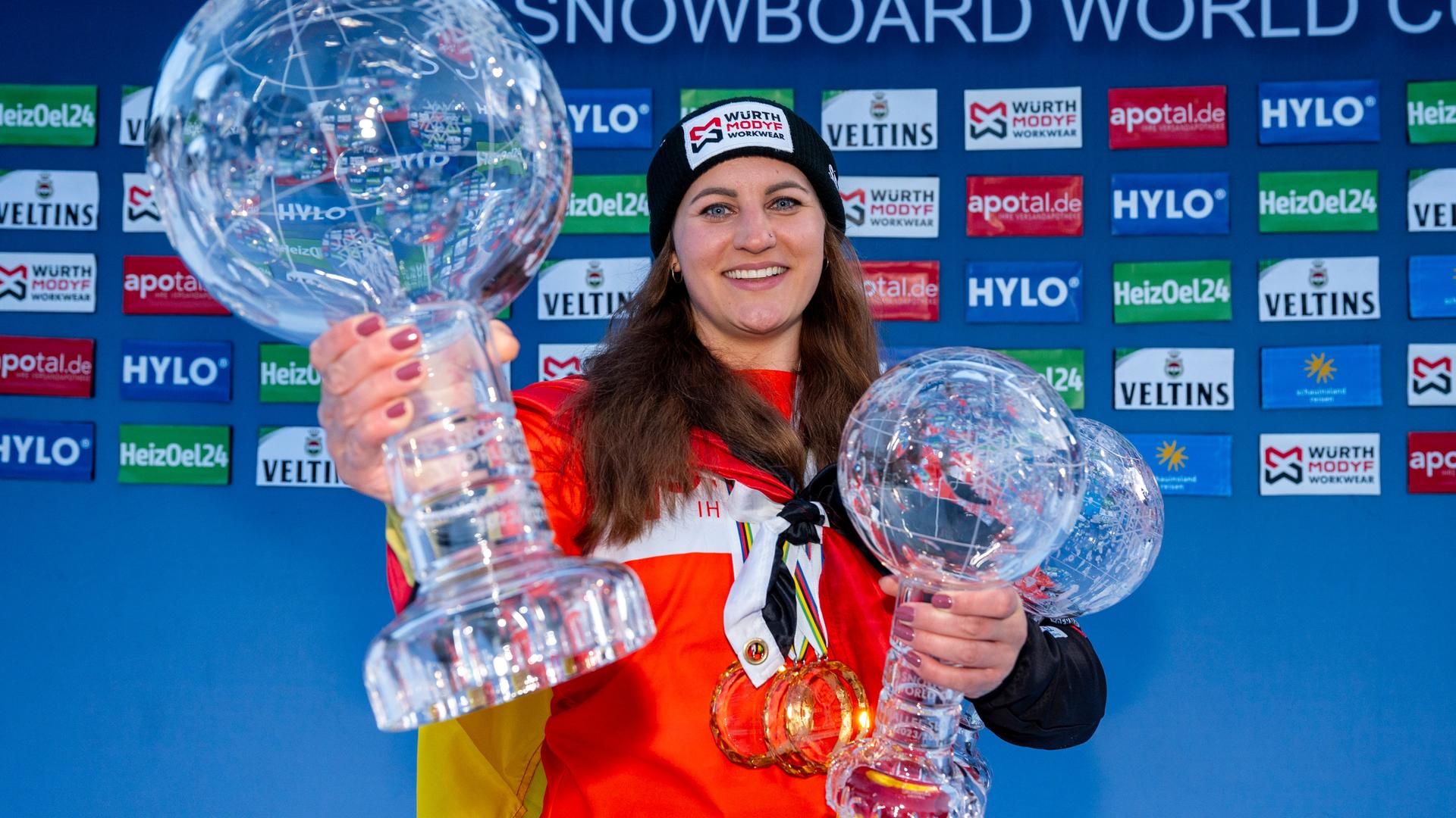 Ramona Hofmeister aus Deutschland zeigt ihre drei Kristallkugel-Pokale und lächelt in die Kamera.