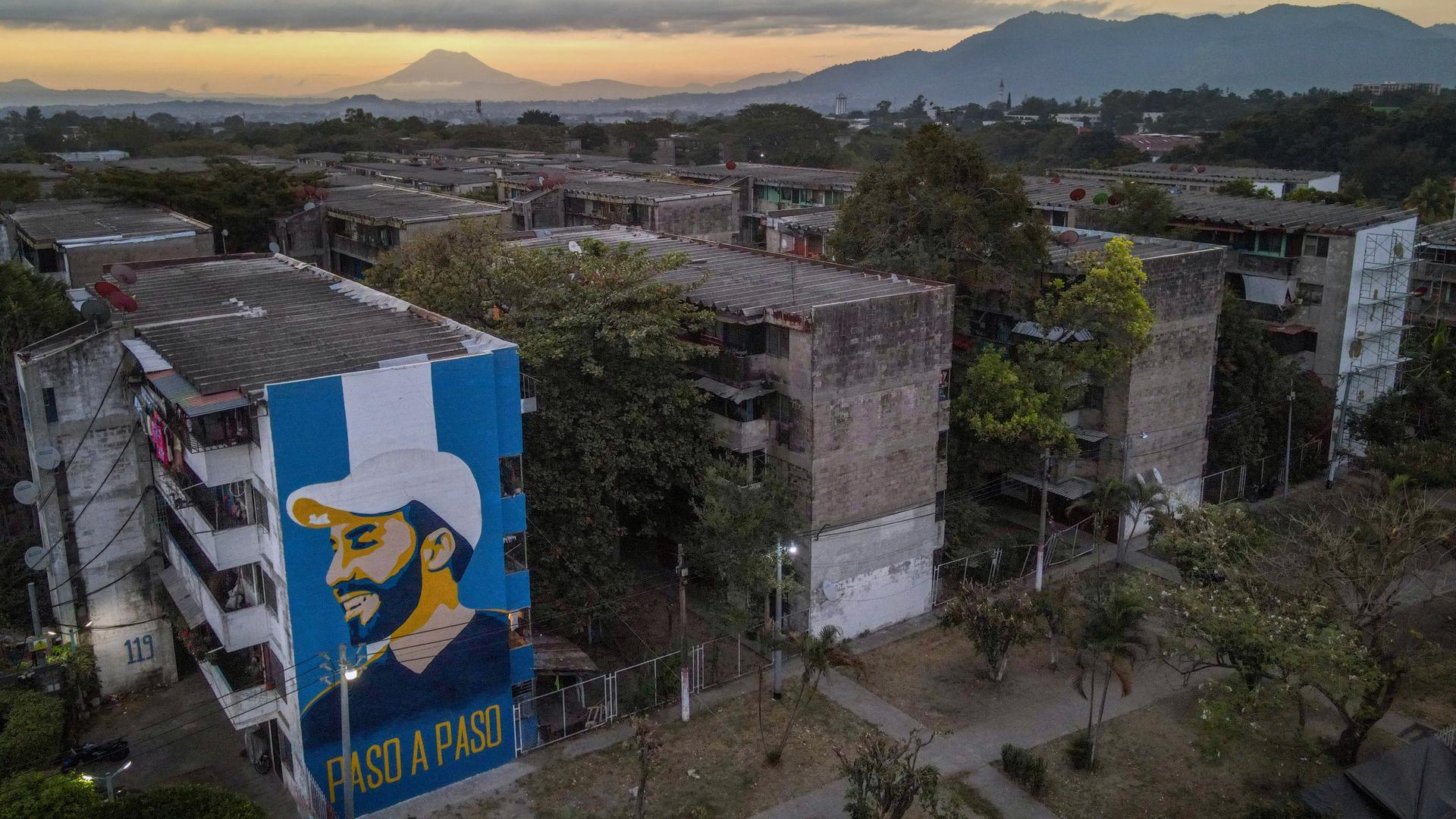 Luftaufnahme eines Apartmentkomplex in Mejicanos. An einer Gebäudewand prangt das riesige Porträt Nayib Bukeles.
