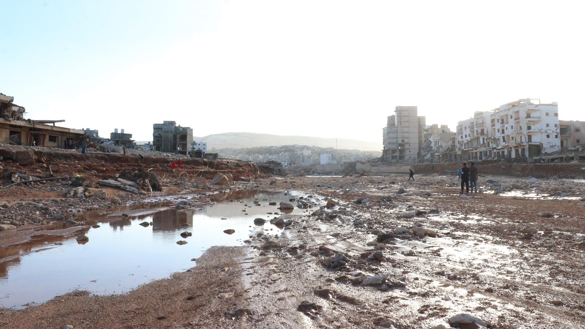 Blick auf eine verschlammte Fläche zwischen Häusern in der libyischen Stadt Darna.