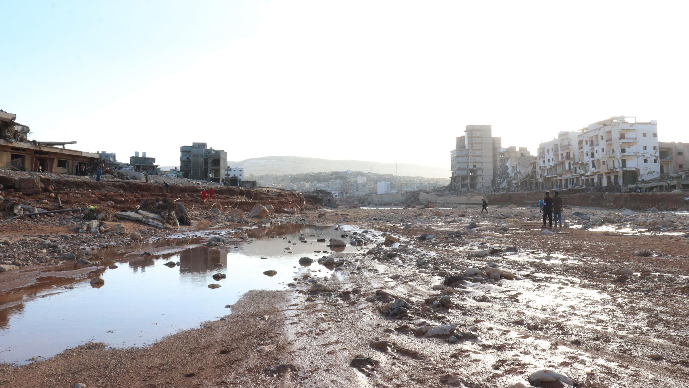 Blick auf eine verschlammte Fläche zwischen Häusern in der libyischen Stadt Darna.