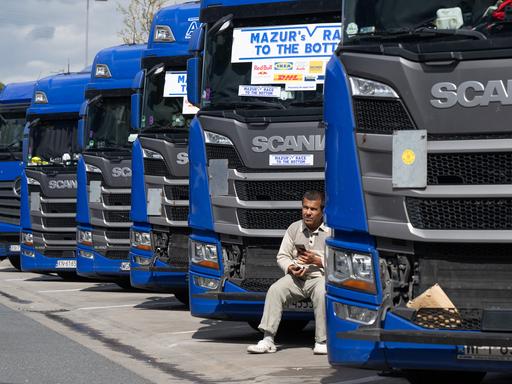 Ein Trucker aus Osteuropa sitzt an der Raststätte Gräfenhausen vor dem Kühlergrill seines Lkw. 
