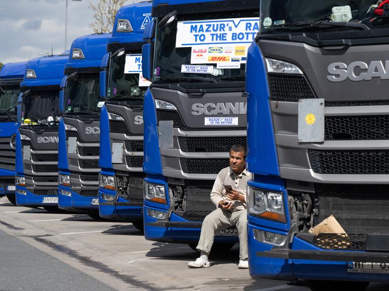 Ein Trucker aus Osteuropa sitzt an der Raststätte Gräfenhausen vor dem Kühlergrill seines Lkw. 