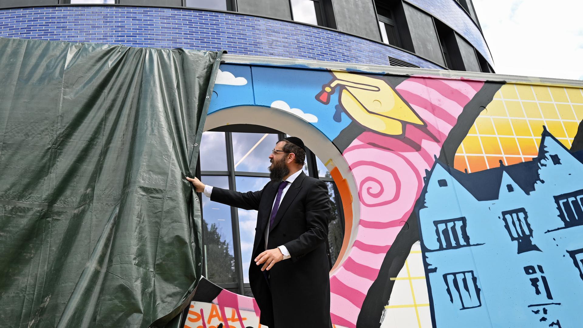 Rabbiner Yehuda Teichtal enthüllt in Berlin das Graffiti an einer Mauer des Pears Jüdischen Campus in Berlin Wilmersdorf.