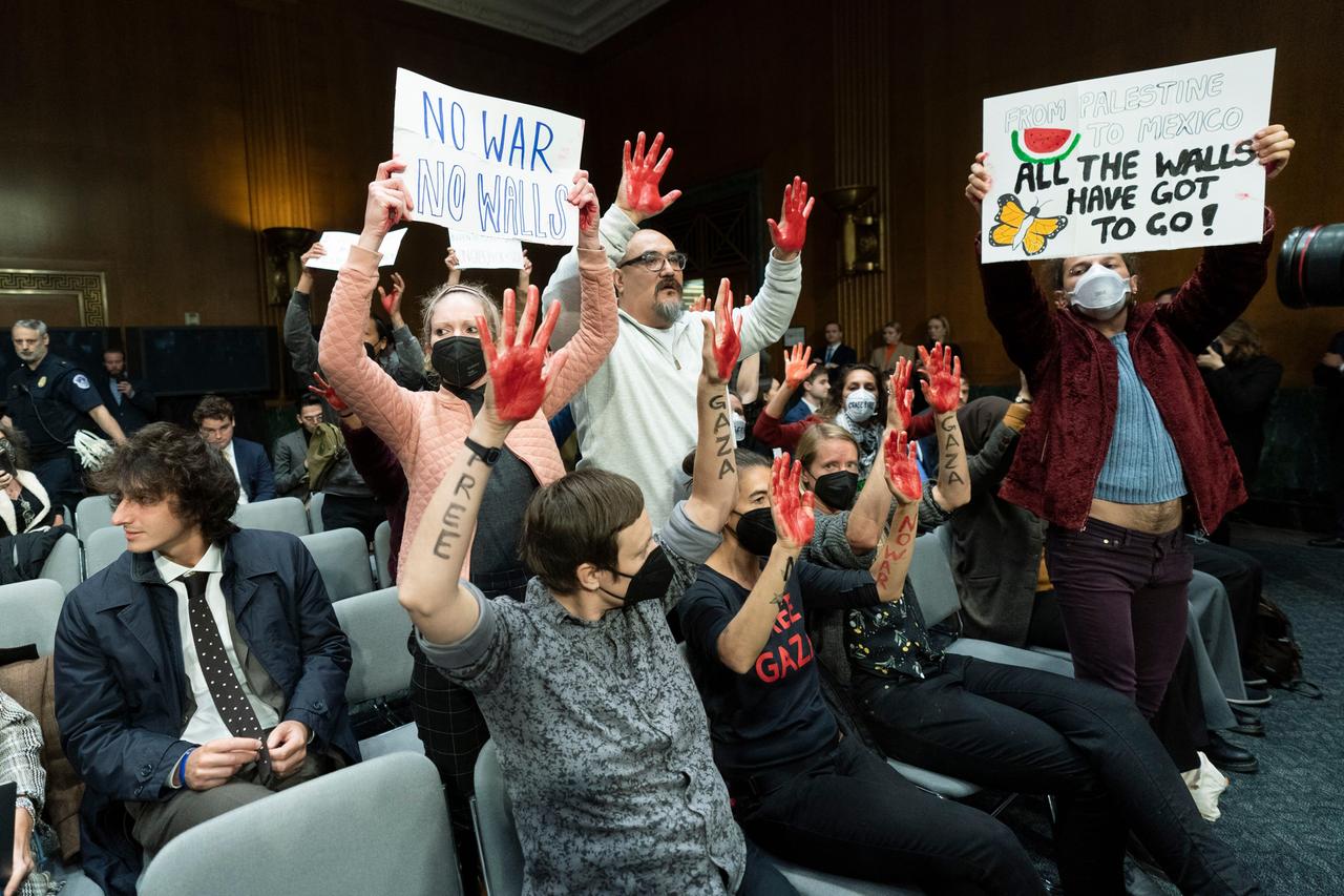 USA, Washington: Demonstranten skandieren Slogans und schwenken Transparente im Anhörungssaal während einer Anhörung des Bewilligungsausschusses des Senats zur Prüfung des Zusatzantrags zur nationalen Sicherheit auf dem Capitol Hill. 