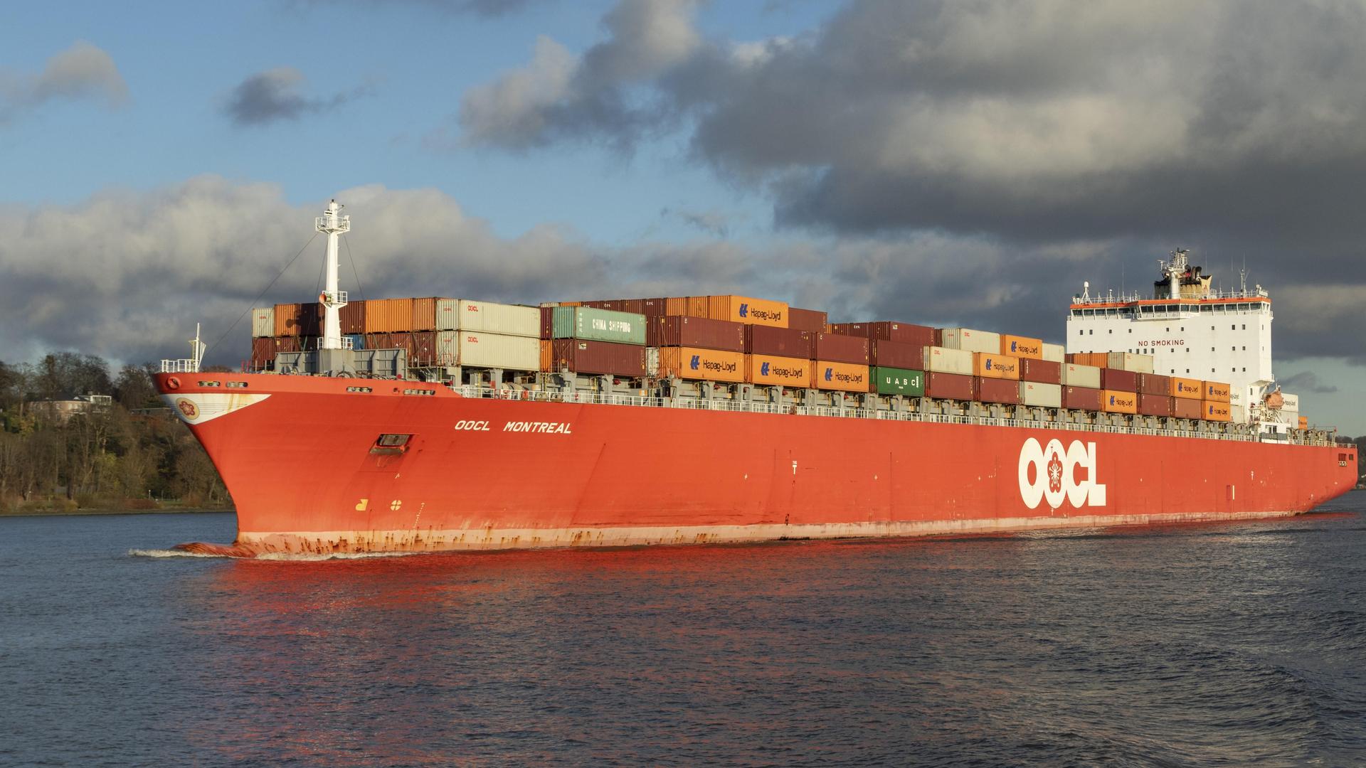 Ein Container-Schiff mit vielen gestapelten Containern auf dem Wasser