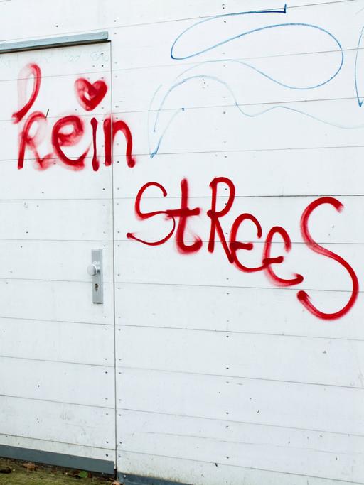 Ein rotes Graffiti an einer Wand: "Kein Strees" mit Herz daneben.