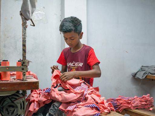 Ein Junge arbeitet bei einem Bekleidungshersteller in Dhaka, Bangladesch.