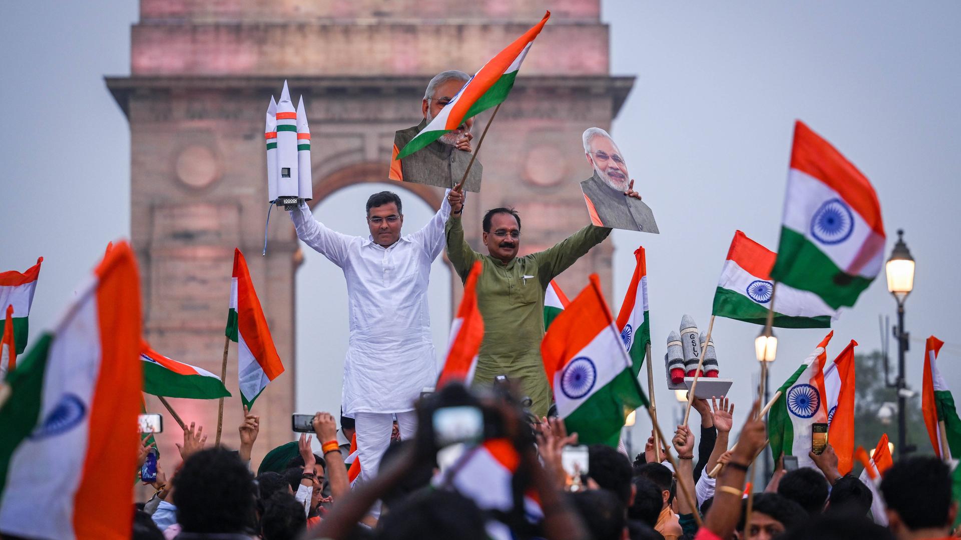 Der BJP-Abgeordnete Parvesh Sahib Singh Verma und der Präsident der BJP von Delhi, Virendra Sachdeva, feiern mit anderen Menschen auf einer Straße in Neu-Delhi die erfolgreiche Landung des Chandrayan3 Vikaram Lander auf dem Mond