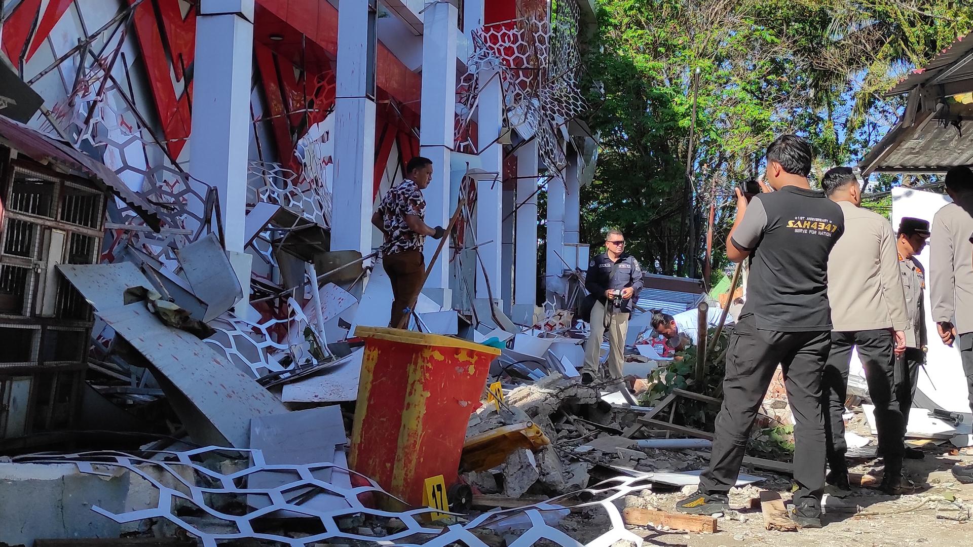 Polizisten inspizieren ein beschädigtes Gebäude nach einem Erdbeben in Manado, Nordsulawesi, Indonesien. Polizisten inspizieren ein beschädigtes Gebäude nach einem Erdbeben in Manado, Nordsulawesi, Indonesien.