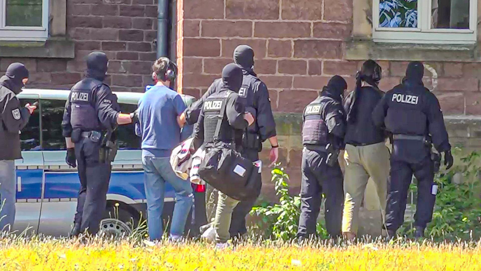 Zwei der Terrorverdächtigen werden von Polizisten zur Vorführung vor dem Haftrichter gebracht. 