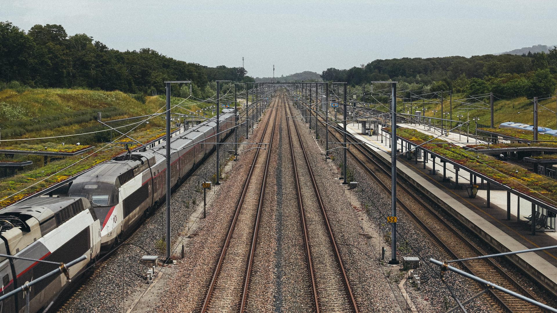 Die TGV-Station in Besançon mit einem Zug auf den Gleisen. Daneben leere Schienen.